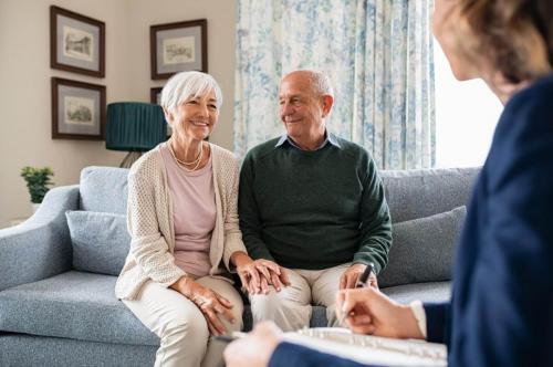 Smiling senior couple with counselor on couch