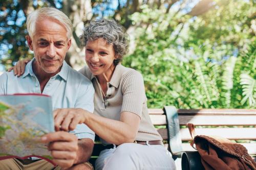 Senior couple looking at map on park bench